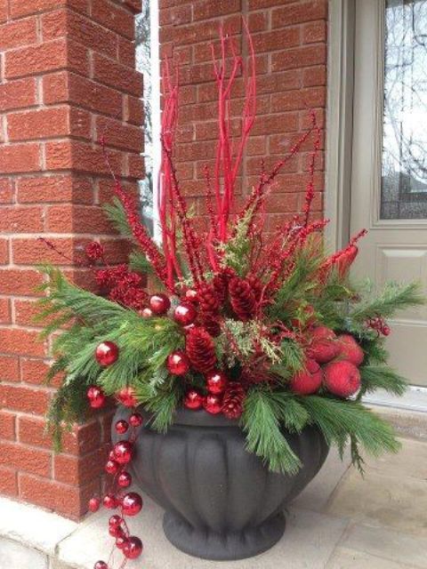 outdoor arrangement with a large urn, evergreens, red branches and ornaments is perfect for a welcoming Christmas porch decor