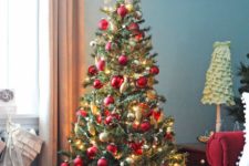 a bright Christmas tree with red and gold ornaments and placed in a rustic crate looks sweet and excessive as this crate creates a harmonious look with the bold tree
