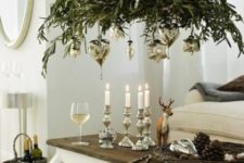 11 greenery chandelier topped with candles and with hanging silver ornaments