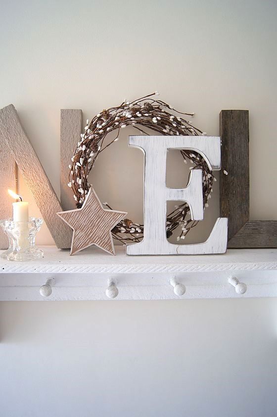 neutral Christmas mantel with letters, a candle and a star