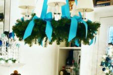 12 a usual chandelier covered with an evergreen wreath and turquouse ribbon