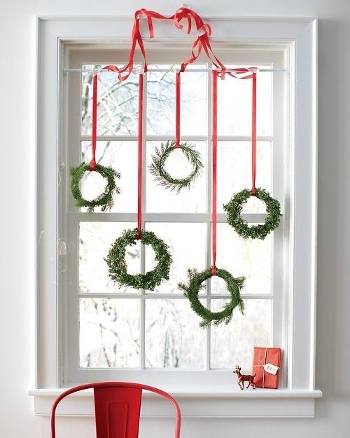 an assortment of small evergreen wreaths with red ribbon
