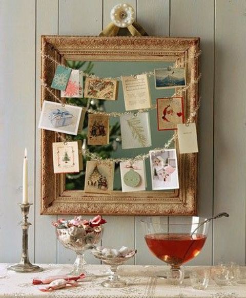 a framed mirror with garlands and  hanging photos and cards on them