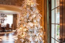 13 a large Christmas tree with white and silver decorations