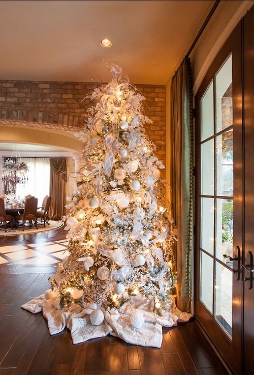 a large Christmas tree with white and silver decorations
