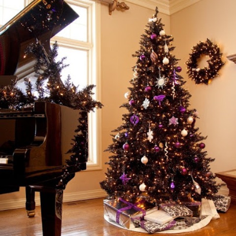 a wreath and  tree in black is chic and purple adds just the pop of color to this living room