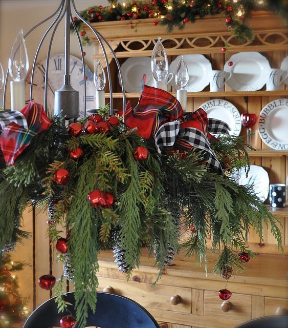 cute chandelier with plaid ribbon bows, fir branches and red jungle bells