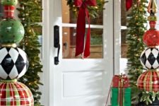 13 whimsy porch decor with evergreen garlands, lights, large ornament topiaries and gift boxes