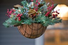 14 a hanging arrangement with evergreens, pinecones, berries and leaves