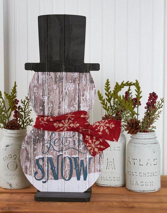 painted snowman-shaped sign 'Let It Snow'