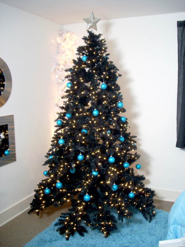 a black tree decorated with lights and turquoise baubles for a contrast