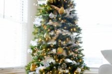 a glam Christmas tree styled with white and gold ornaments and lights and in a galvanized bucket that makes ita bit rustic