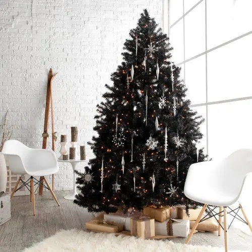 a lush black tree wwith white and silver snowflake ornaments and lights