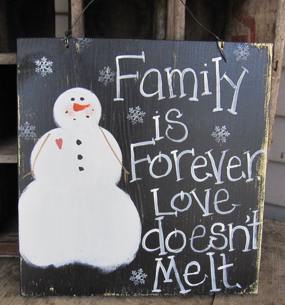 simple and primitive snowman sign on reclaimed wood