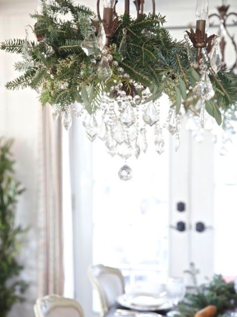 vintage chandelier decorated with foliage, evergreens and crystals