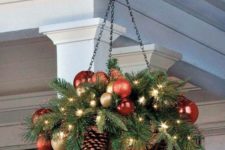 18 a hanging arrangement wwith ornaments, lights and evergreens
