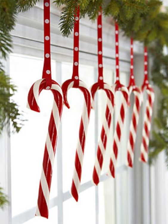candy canes hanging from an evergreen garland are ideal for holidays