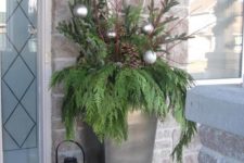 19 a metal urn with evergreens, pinecones and ornaments