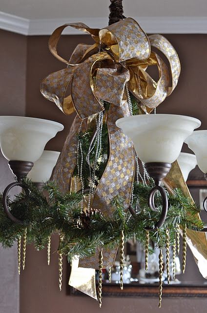 gold and silver ribbon, evergreen branches with pinecones to cover a chandelier