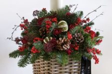 20 a basket arrangement with pinecones, berries and evergreens