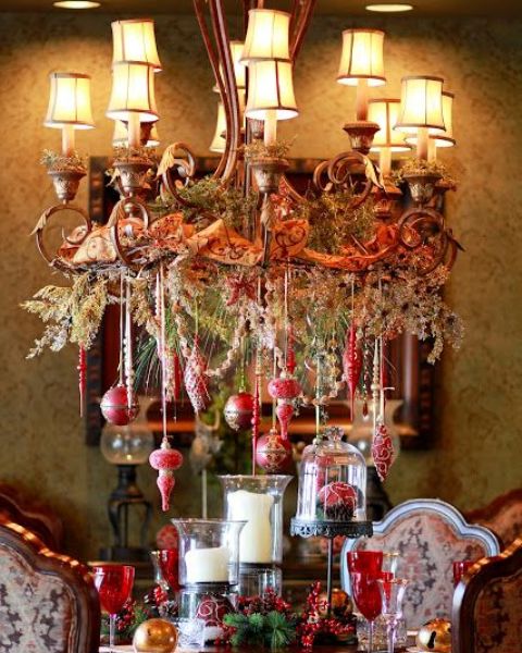 beautiful Christmas chandelier with hanging red ornaments, vintage ribbon and evergreens