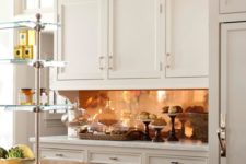 21 plain white cabinets are glamed up with a polished copper backsplash