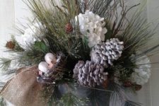 23 a bucket with evergreens, snowy pinecones and flowers