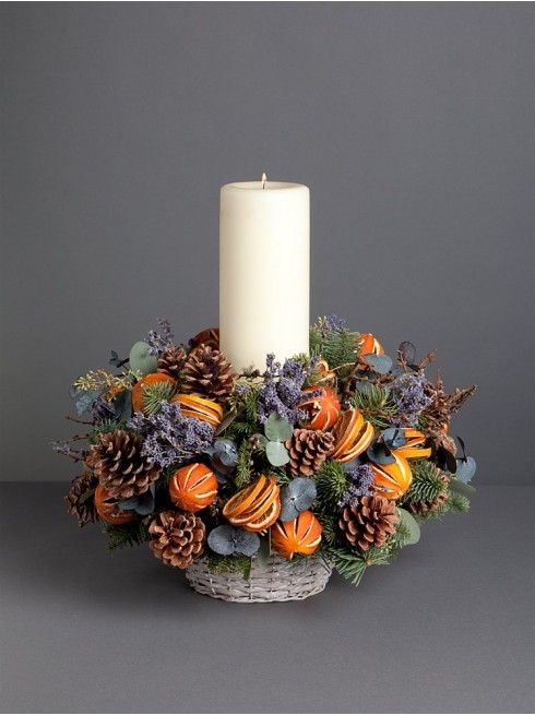 a cool centerpiece with a pillar candle, lavender, pinecones and citrus
