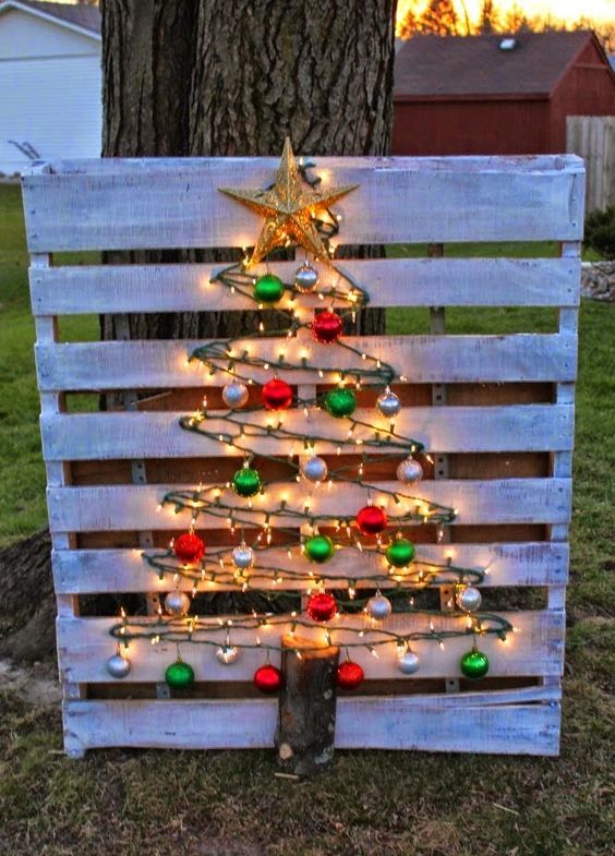 whitewashed pallet sign and a tree made of lights and ornaments