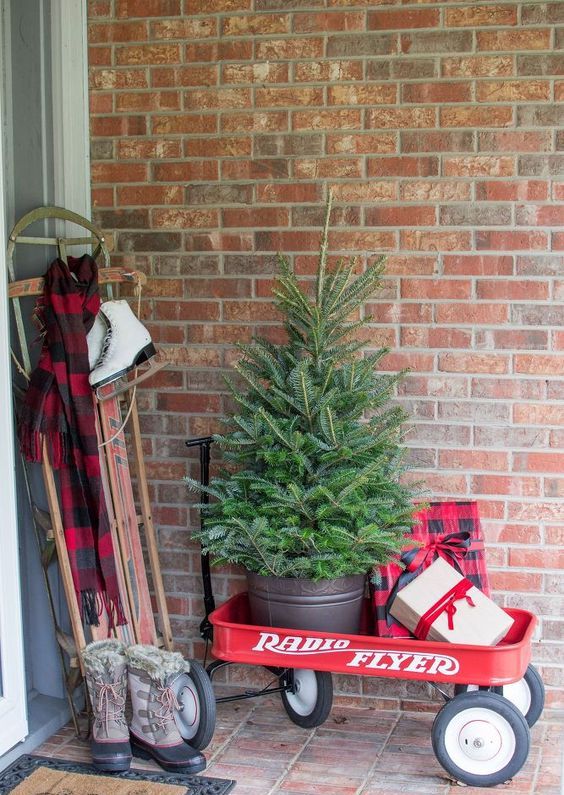 a cart with a fir tree in a bucket, gift boxes and a sleigh