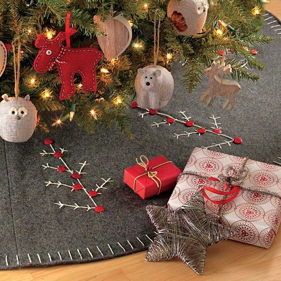 a grey felt skirt with embroidery and button decor showing Christmas trees is a fun and cool idea for a modern or Scandinavian Christmas tree