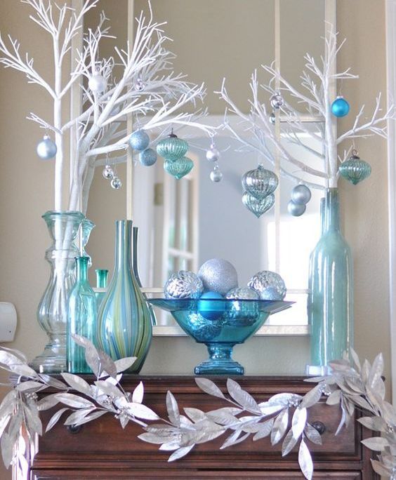 silver, blue and white mantel decor with white branches and leaves