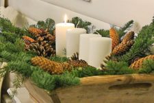 29 a wooden dough bowl with evergreens, pinecones and pillar candles