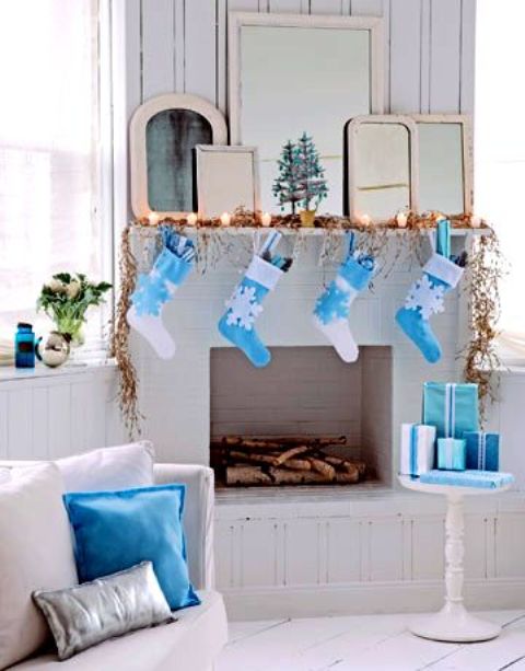 a crispy white and blue Christmas mantel, gifts, stockings and pillows