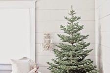 a minimal Christmas tree without decor with a cozy knit blanket as a tree skirt is a super chic and very natural-looking solution