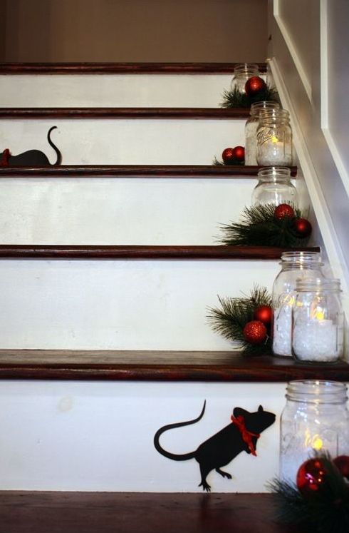 evergreens, small red ornaments, candle holders on the steps