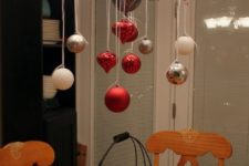 30 place some branches with berries on the chandelier and hang some ornaments