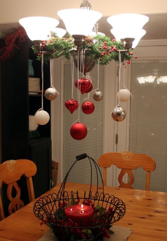 place some branches with berries on the chandelier and hang some ornaments