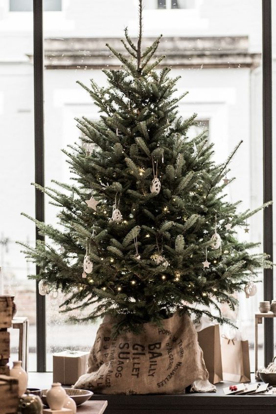 if you want to add an industrial and vintage touch, opt for an old sack wrapping instead of a usual Christmas tree cover