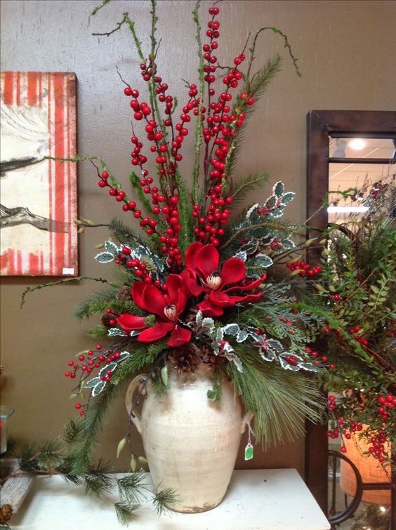 a vintage jug with evergreens, berries, pinecones and flowers is perfect for Christmas entryway display