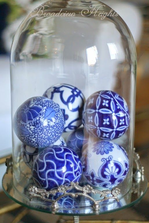 blue and white ornaments in a cloche as a Christmas display