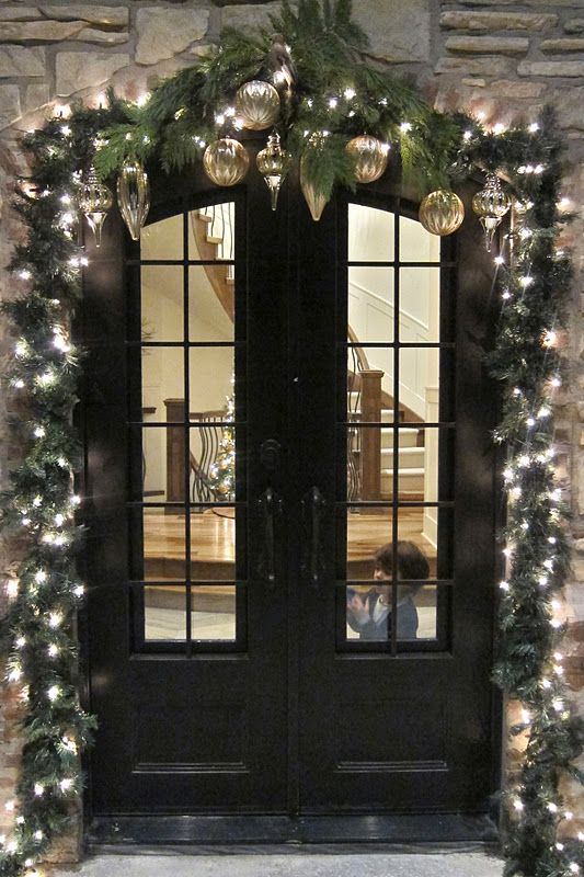evergreen garland with lights and ornaments over the doors