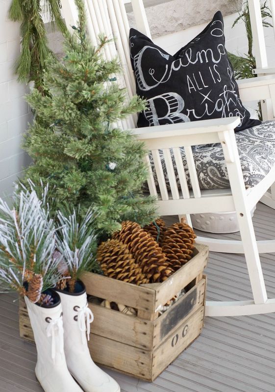 a white rocker, an industrial crate filled with pinecones, a fir tree