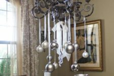 34 silver and metallic grey ornaments hanging on the chandelier