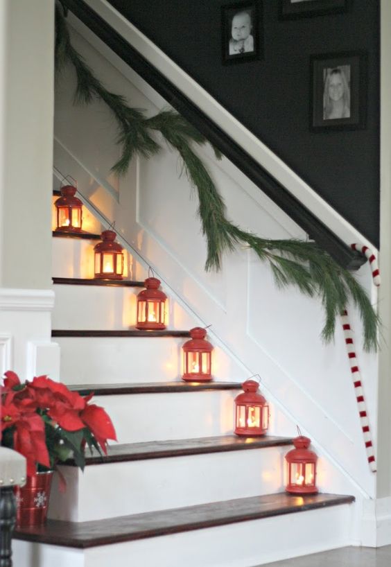 red lanterns placed on the stairs and an evergreen garland