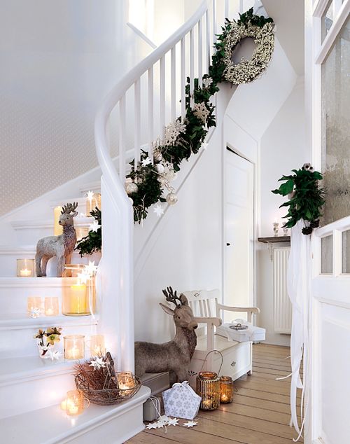 steps decorated with a foliage and paper garland, candles and figures