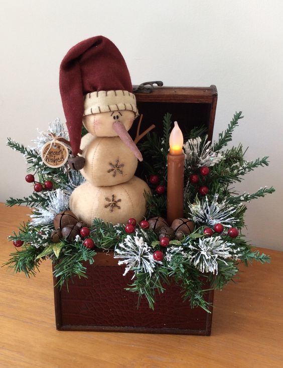 vintage chest with fir branches, a snowman and a candle lamp