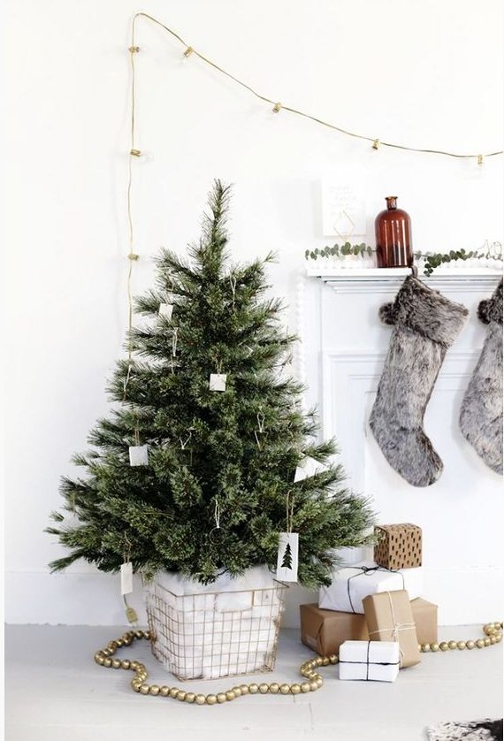 a Nordic Christmas tree with white ornaments and some himmeli ones, put into a wire basket with cotton is a pretty and easy idea