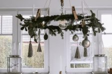 a Scandinavian Christmas chandelier with evergreens, tassels, ornaments is a cool and laconic idea