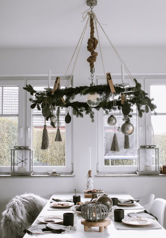 a Scandinavian Christmas chandelier with evergreens, tassels, ornaments is a cool and laconic idea